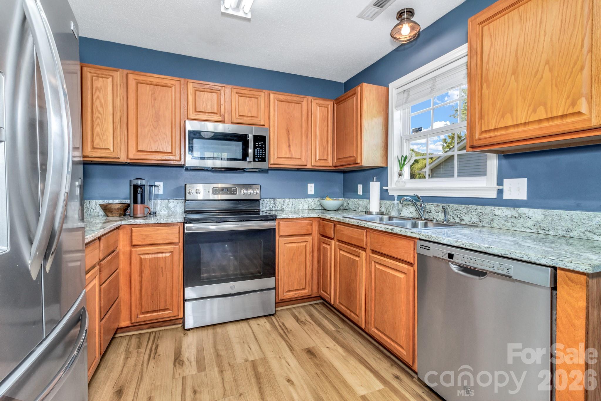 58 South Sunberry Trail Fletcher, NC 28732 - Photo 11 of 41 a kitchen with stainless steel appliances granite countertop a stove a sink dishwasher and a microwave oven with cabinets