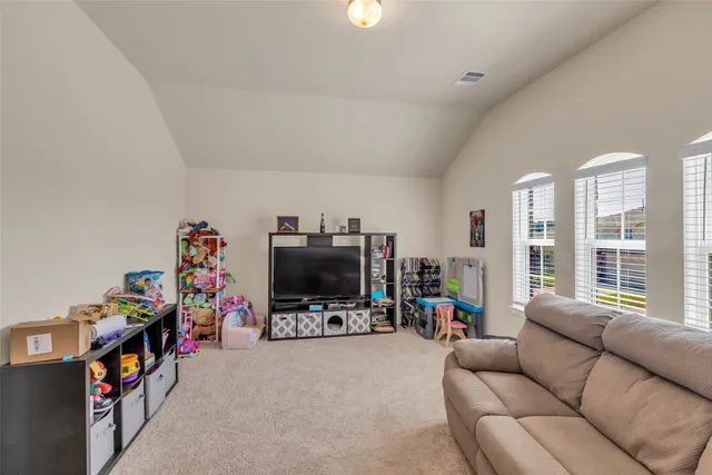 a living room with furniture a flat screen tv and a window