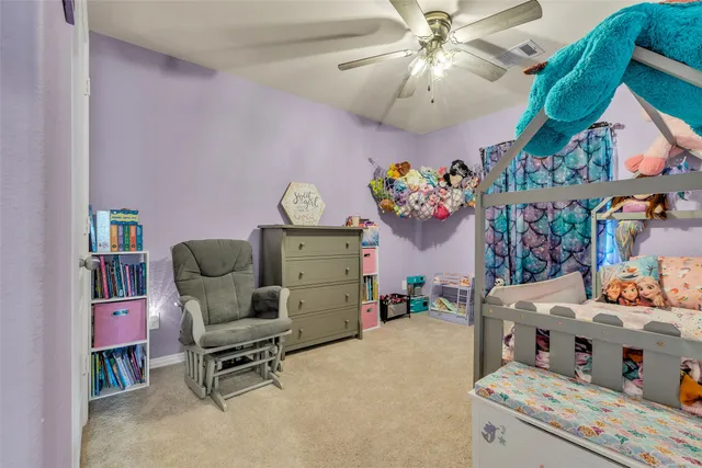 a living room with furniture and a baby crib
