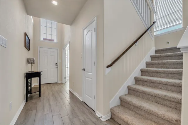 a view of an entryway with wooden floor and staircase