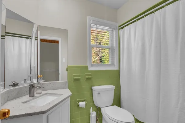 a bathroom with a toilet a sink and a mirror