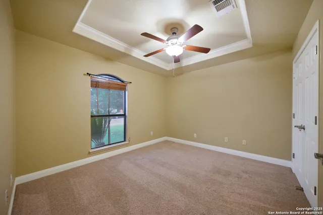an empty room with fan and windows