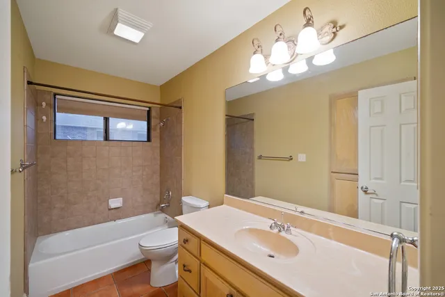 a bathroom with a sink a toilet a mirror a vanity and bathtub