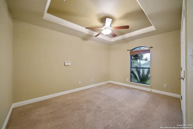 an empty room with windows and fan