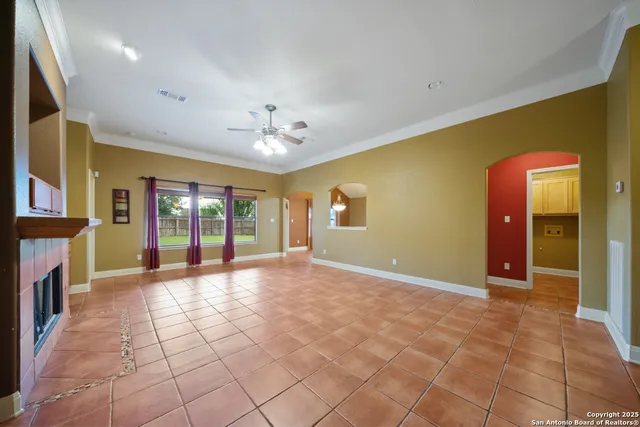 a view of an empty room with a fireplace and chandelier