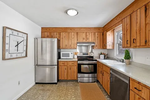 a kitchen with stainless steel appliances granite countertop a sink stove and cabinets
