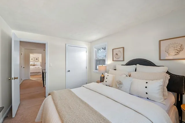 a bedroom with a bed and a lamp on the dresser