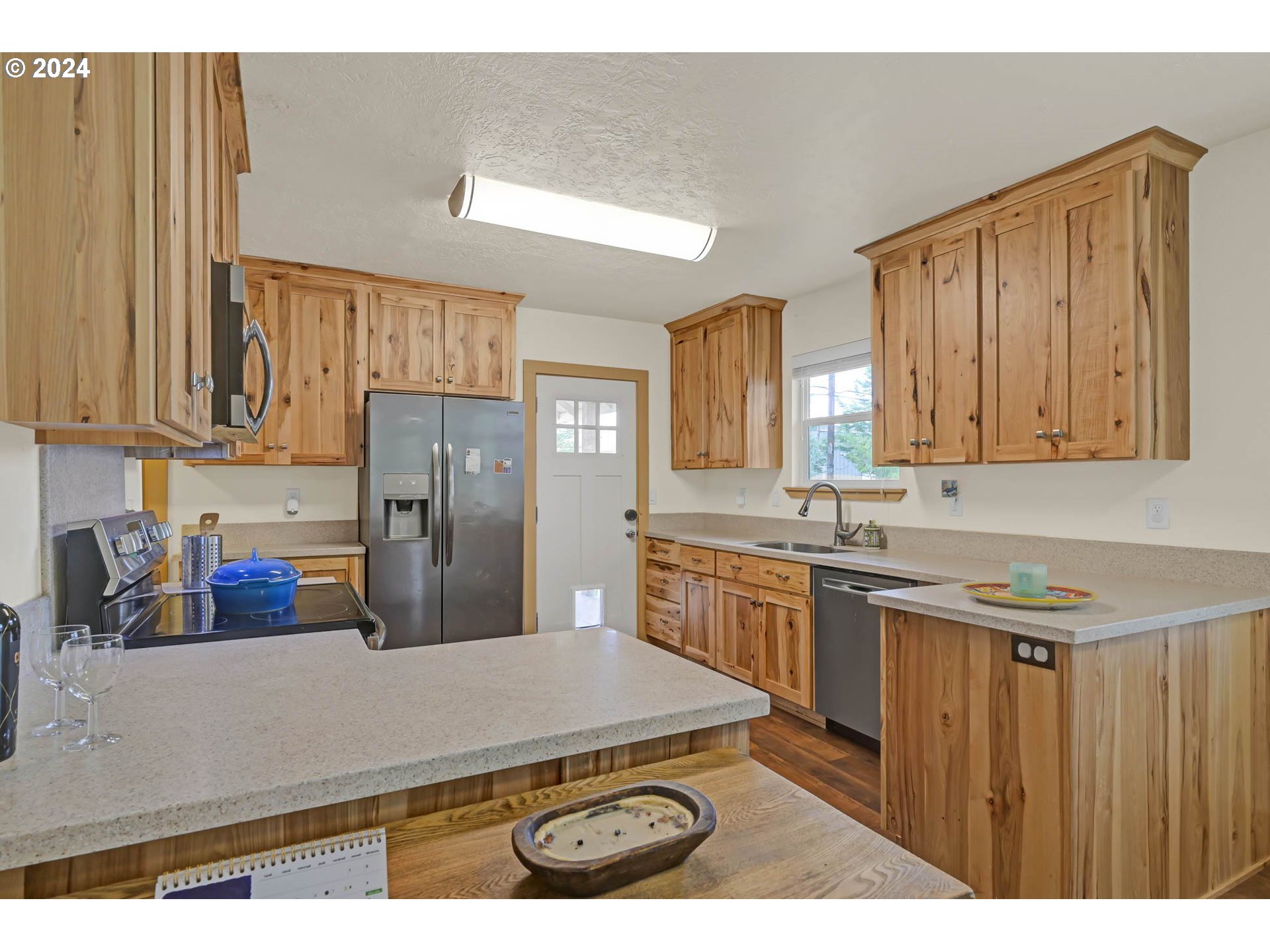 830 G Street Springfield, OR 97477 - Photo 16 of 38 a kitchen with stainless steel appliances a sink a stove a refrigerator cabinets and a counter top space