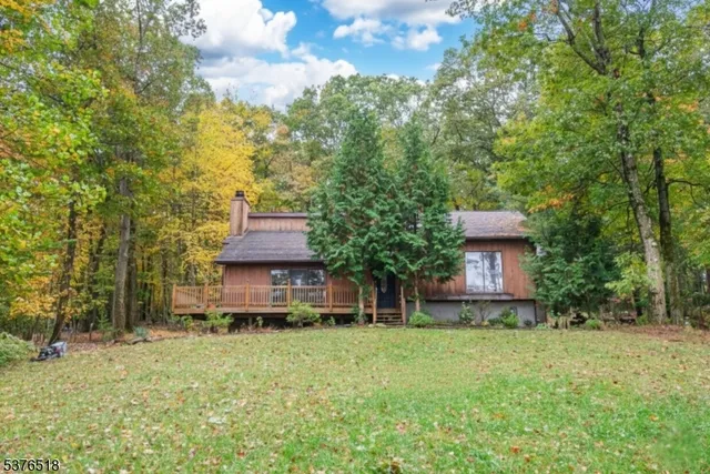 a front view of a house with a garden and trees