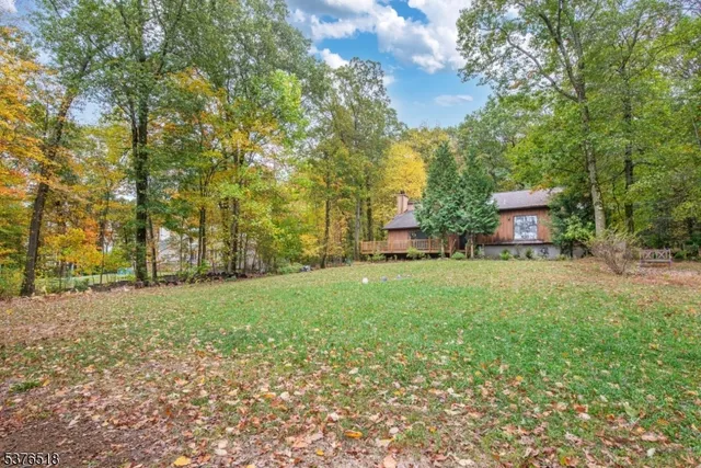 a front view of a house with a yard and tree