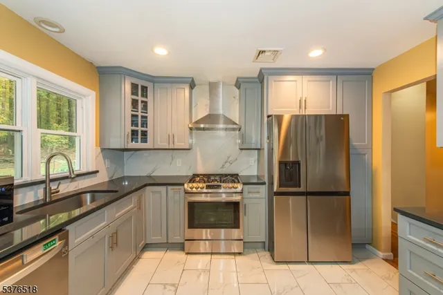 a kitchen with stainless steel appliances granite countertop a refrigerator and a sink