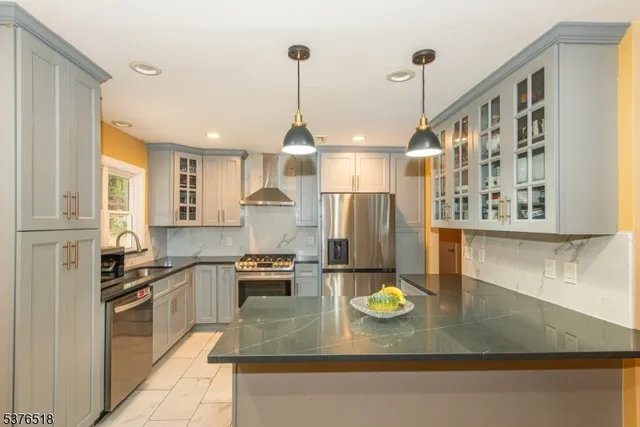 a kitchen with stainless steel appliances granite countertop a sink a stove counter space and cabinets