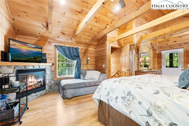 a spacious bedroom with a bed and a flat screen tv