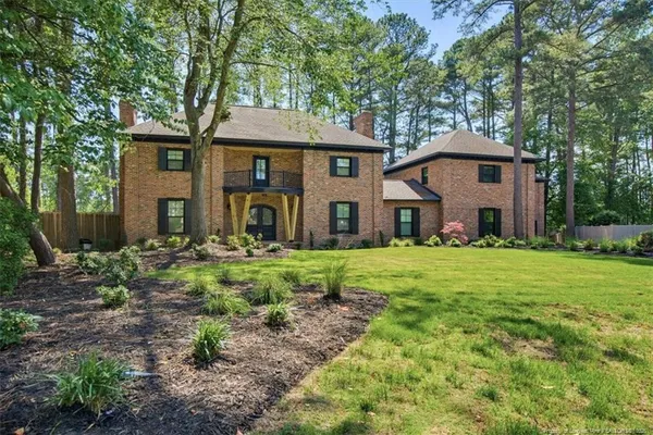 a front view of a house with yard and green space