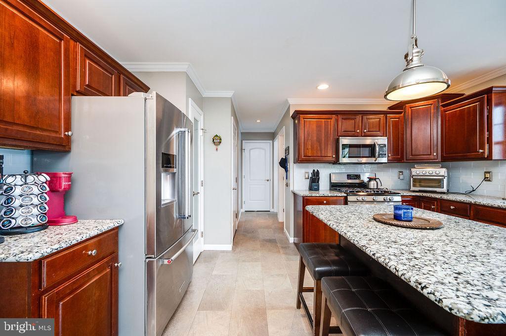 36 Pickwick Place Birdsboro, PA 19508 - Photo 23 of 72 a kitchen with stainless steel appliances granite countertop a refrigerator a sink dishwasher a stove and a dining table with wooden cabinet