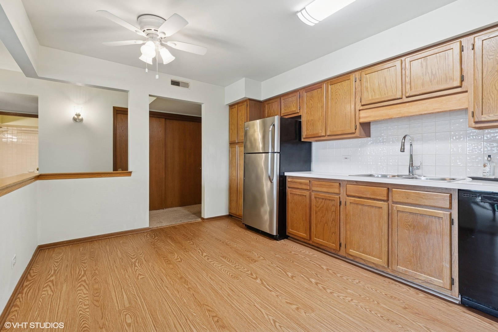 5225 North Riversedge Terrace, Unit 511 Chicago, IL 60630 - Photo 6 of 16 a kitchen with stainless steel appliances granite countertop a refrigerator a sink dishwasher and white cabinets with wooden floor