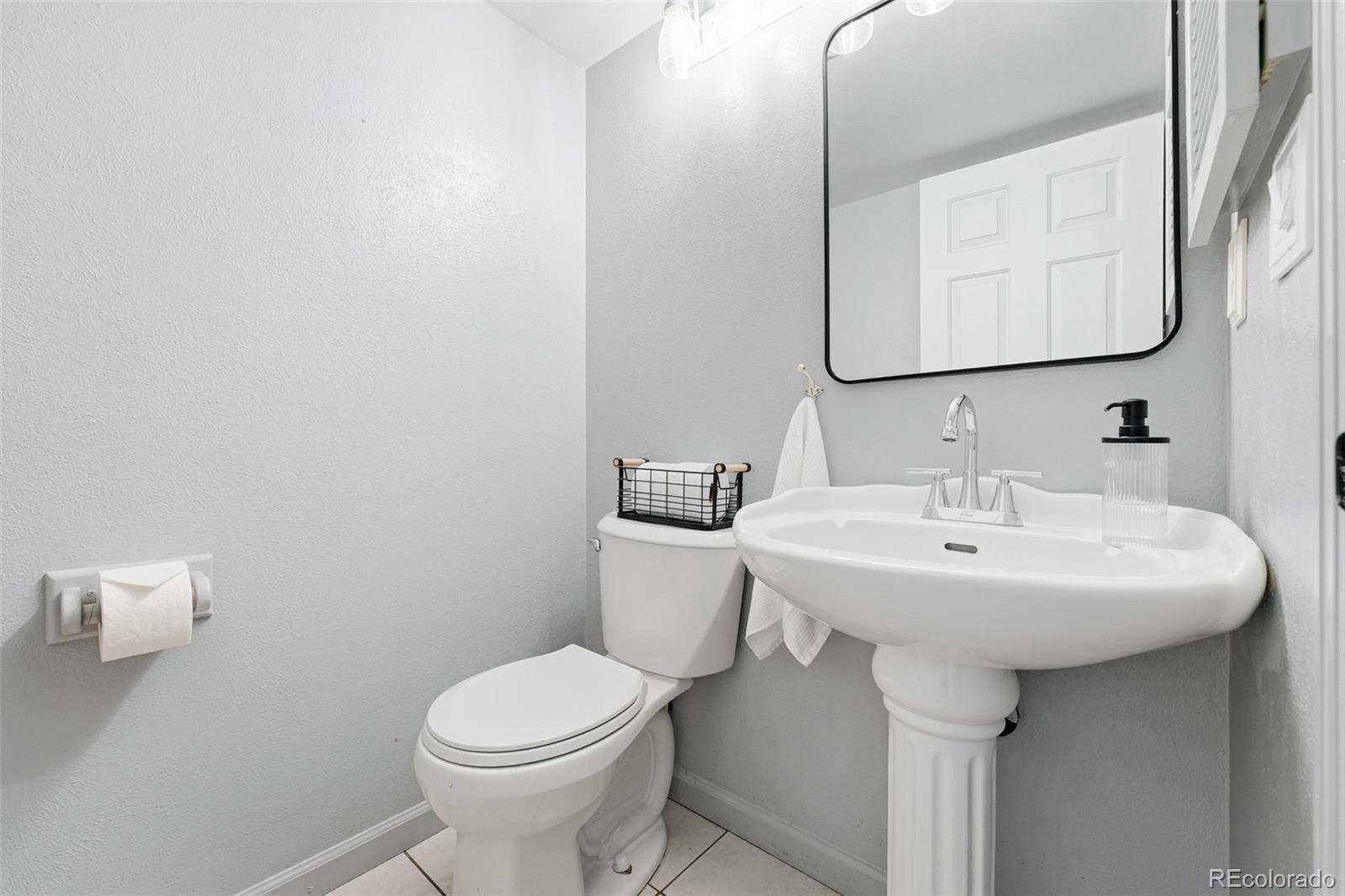 4993 East 111th Place Thornton, CO 80233 - Photo 20 of 50 a bathroom with a toilet sink and mirror