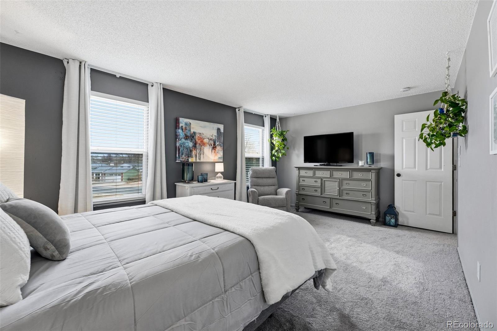 4993 East 111th Place Thornton, CO 80233 - Photo 24 of 50 a large bedroom with a bed and a flat screen television