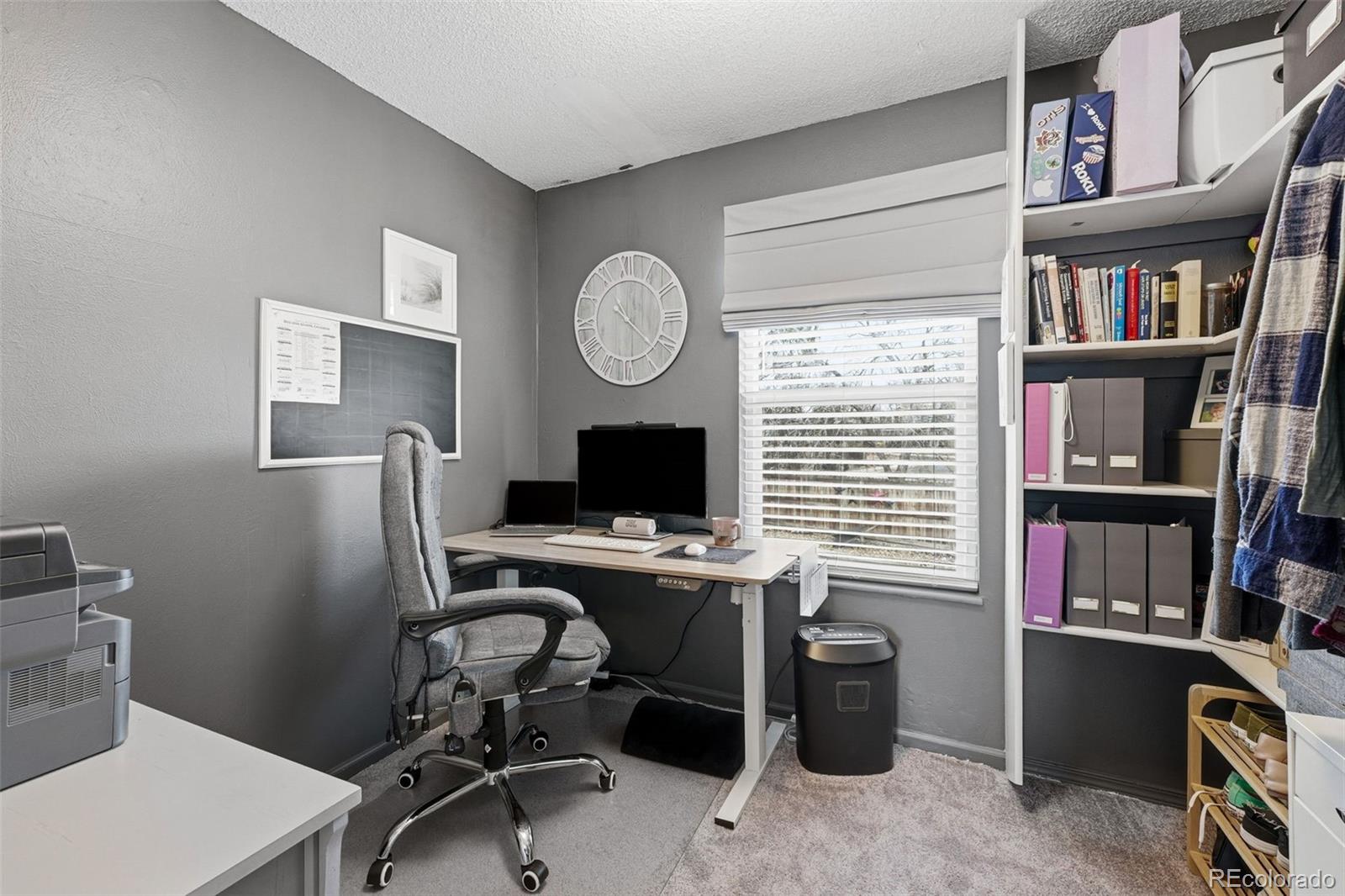4993 East 111th Place Thornton, CO 80233 - Photo 26 of 50 a view of a workspace with furniture and a bookshelf