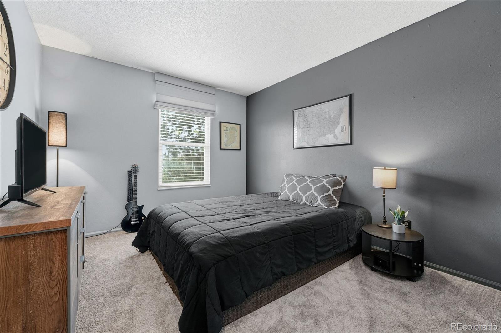 4993 East 111th Place Thornton, CO 80233 - Photo 27 of 50 a bedroom with a bed and a flat tv screen on a dresser