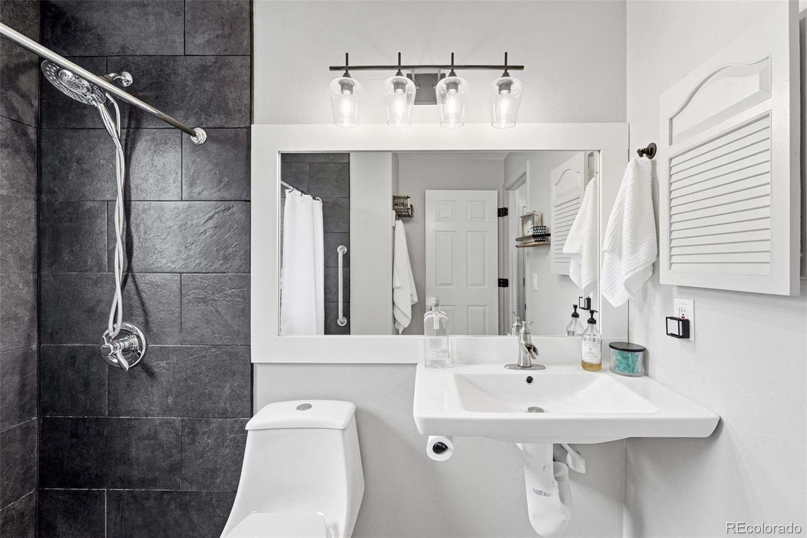 4993 East 111th Place Thornton, CO 80233 - Photo 28 of 50 a bathroom with a sink a mirror and shower