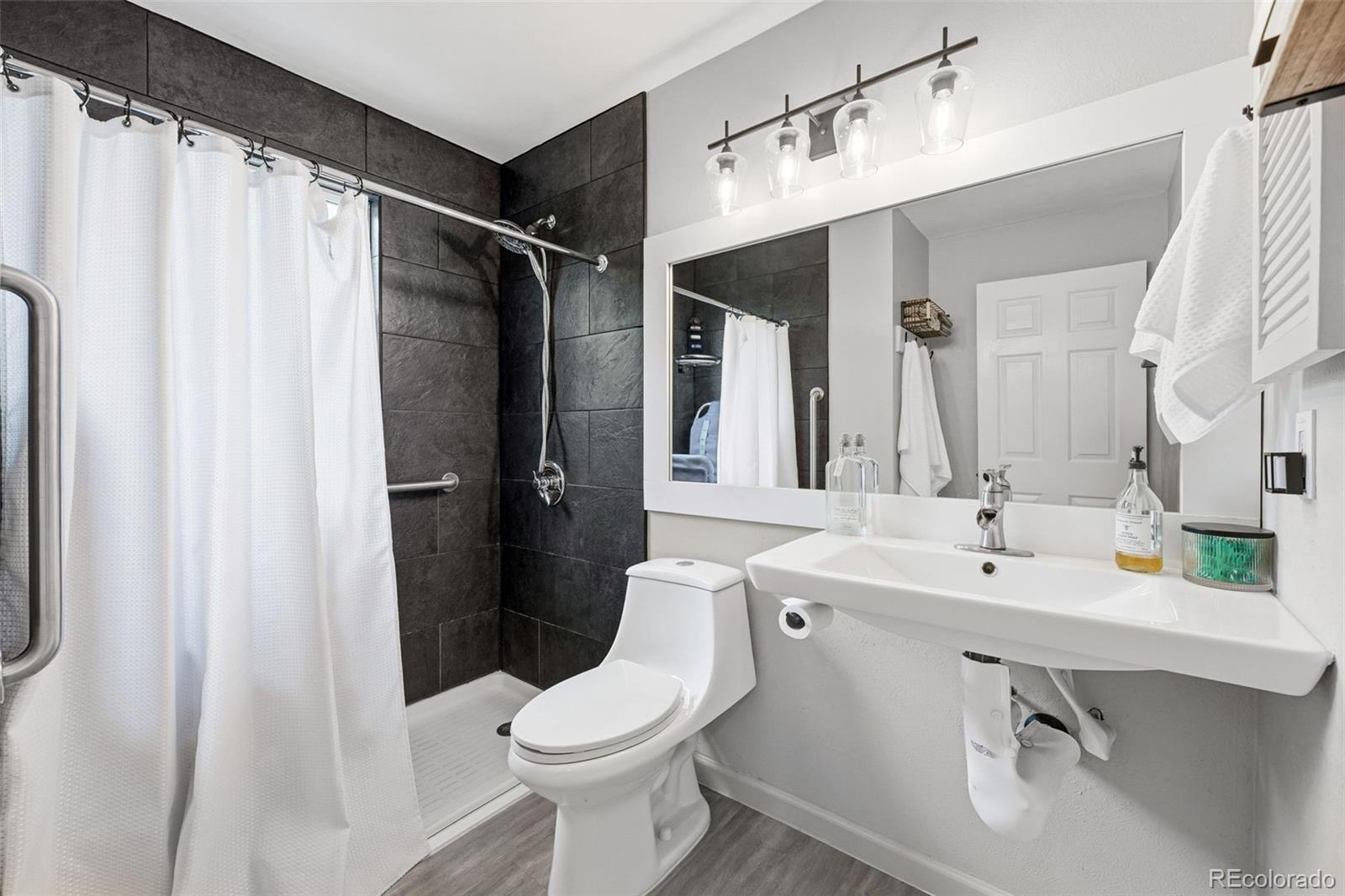 4993 East 111th Place Thornton, CO 80233 - Photo 29 of 50 a bathroom with a sink toilet and shower