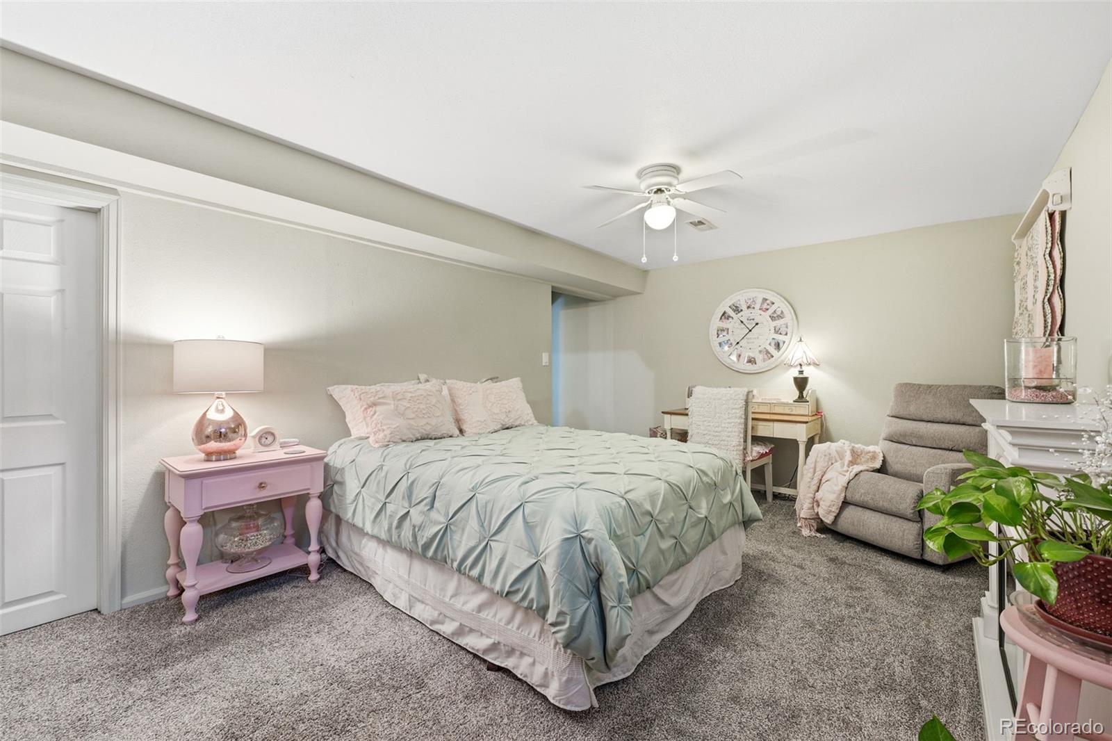 4993 East 111th Place Thornton, CO 80233 - Photo 31 of 50 a spacious bedroom with a bed and a chandelier