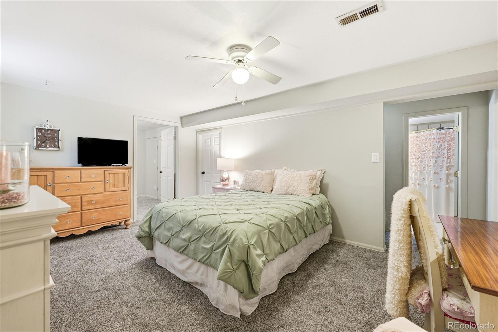 4993 East 111th Place Thornton, CO 80233 - Photo 32 of 50 a spacious bedroom with a bed and tv