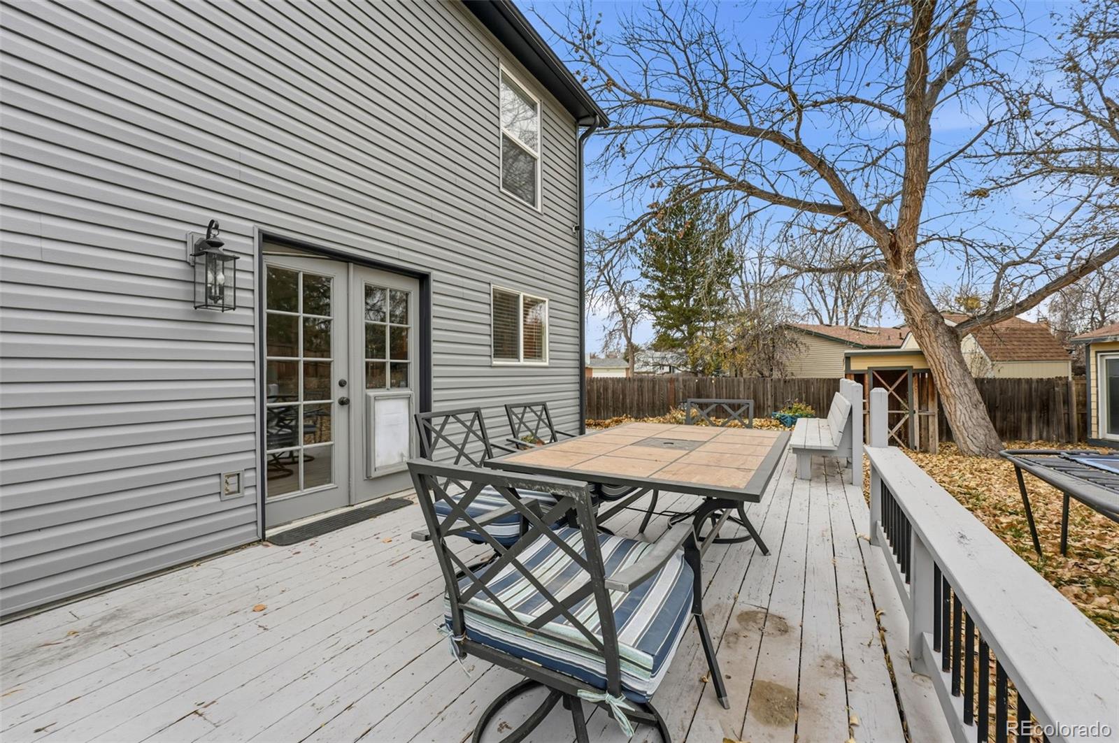 4993 East 111th Place Thornton, CO 80233 - Photo 37 of 50 a view of a patio with table and chairs with wooden floor and fence