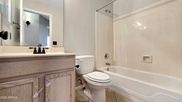 a bathroom with a sink a toilet a mirror and shower