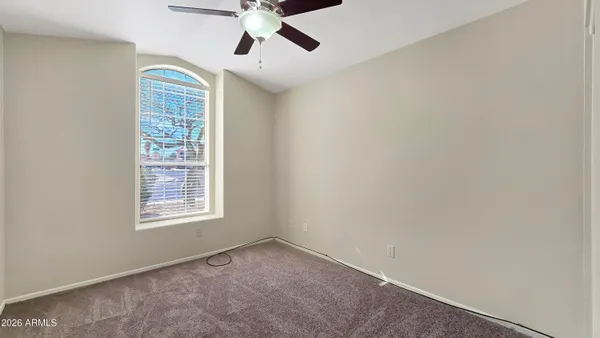 an empty room with windows and fan