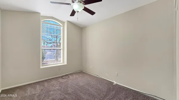 an empty room with windows and fan
