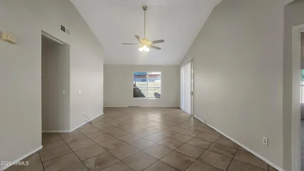 a view of empty room with a ceiling fan and window