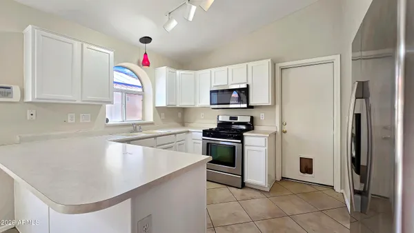 a kitchen with granite countertop a sink stainless steel appliances and cabinets