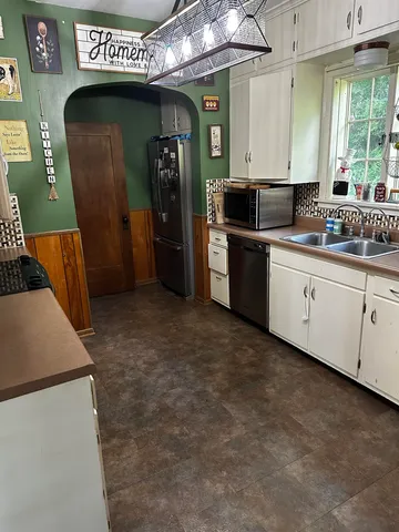 a kitchen with stainless steel appliances granite countertop a refrigerator a sink and a stove