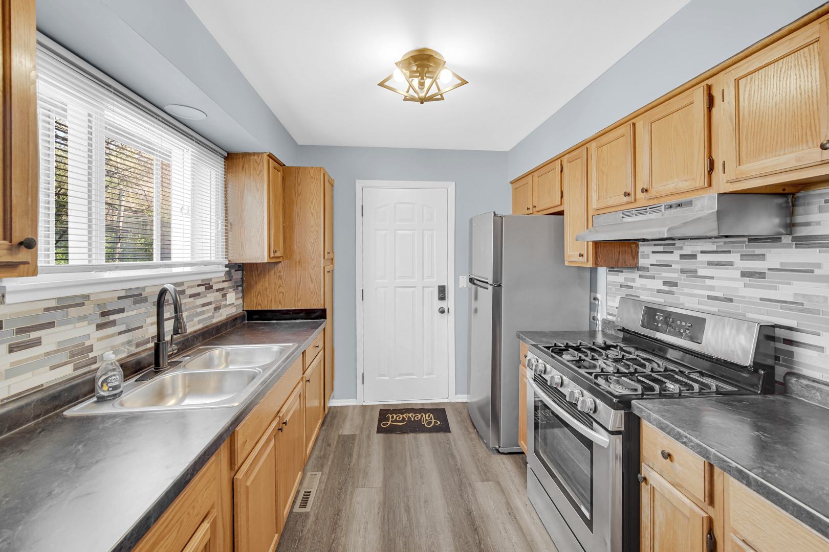 1817 171st Street, Unit 2 Hazel Crest, IL 60429 - Photo 9 of 11 a kitchen with stainless steel appliances granite countertop a sink stove and refrigerator