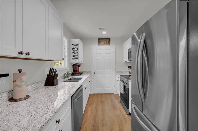 a kitchen with a refrigerator and white cabinets