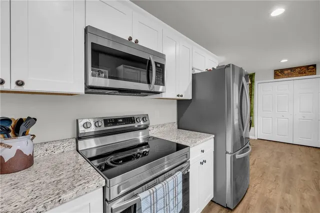 a kitchen with stainless steel appliances granite countertop a stove a microwave and a refrigerator