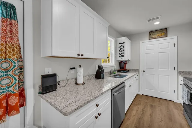 a kitchen with granite countertop a sink stove and cabinets