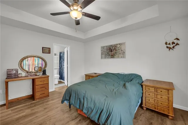 a bedroom with a bed dresser and wooden floor