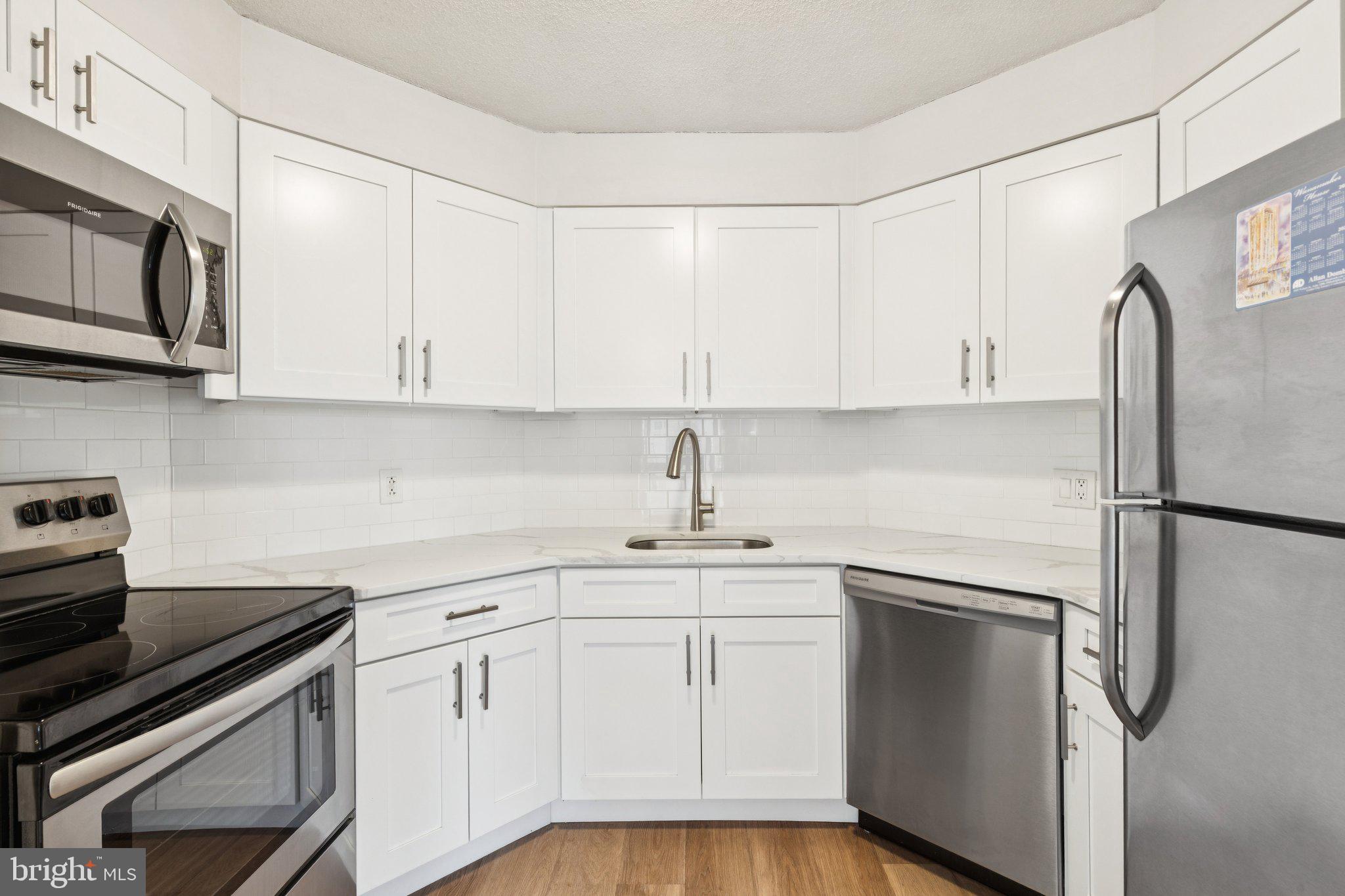 2020 Walnut Street, Unit 14J Philadelphia, PA 19103 - Photo 4 of 25 a kitchen with white cabinets and stainless steel appliances