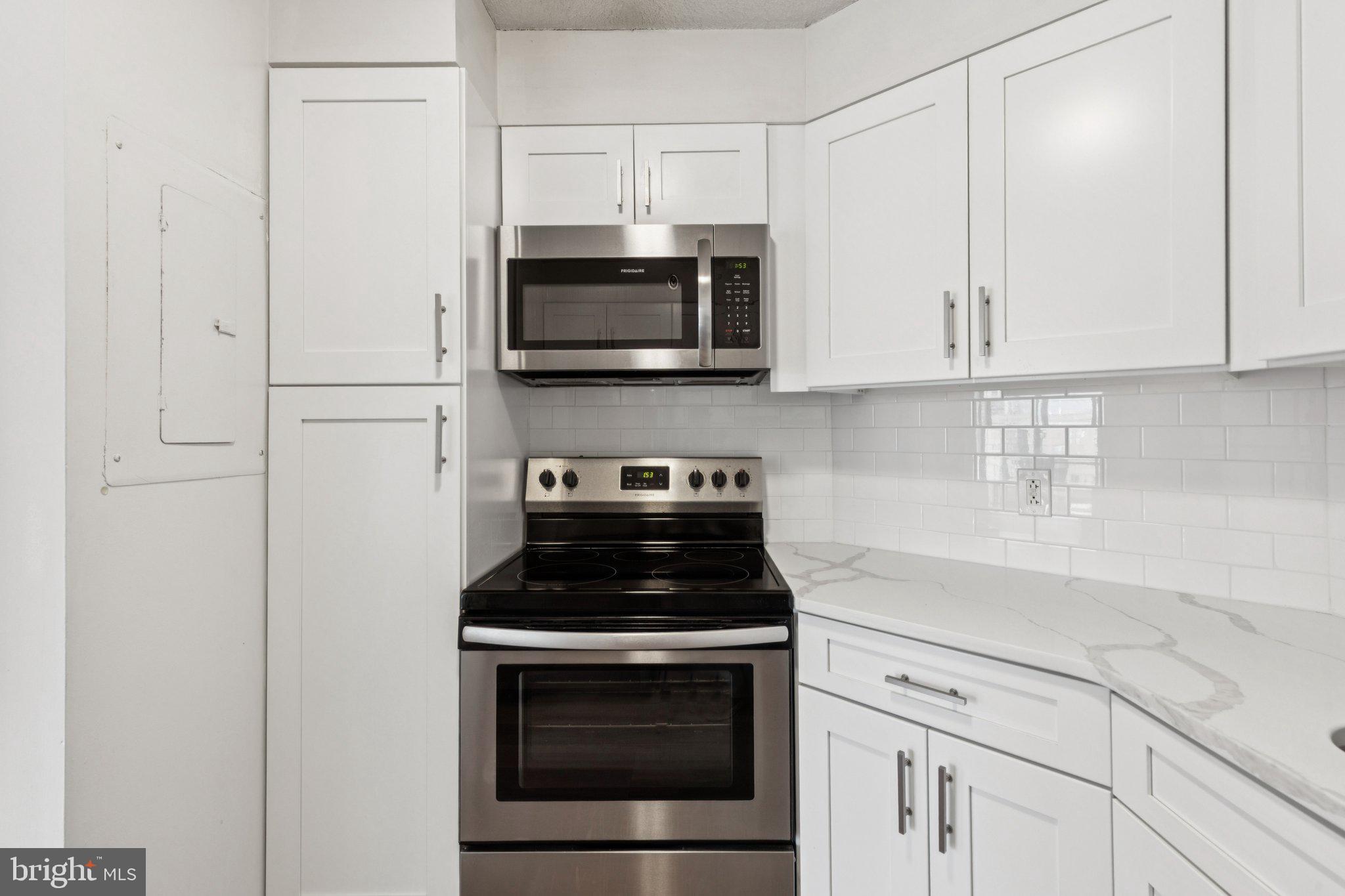 2020 Walnut Street, Unit 14J Philadelphia, PA 19103 - Photo 5 of 25 a kitchen with white cabinets and stainless steel appliances
