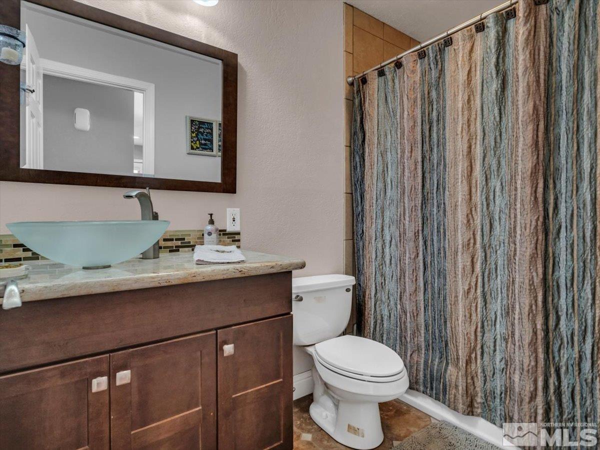 835 Russell Way Gardnerville, NV 89460 - Photo 15 of 40 a bathroom with a granite countertop toilet sink and mirror