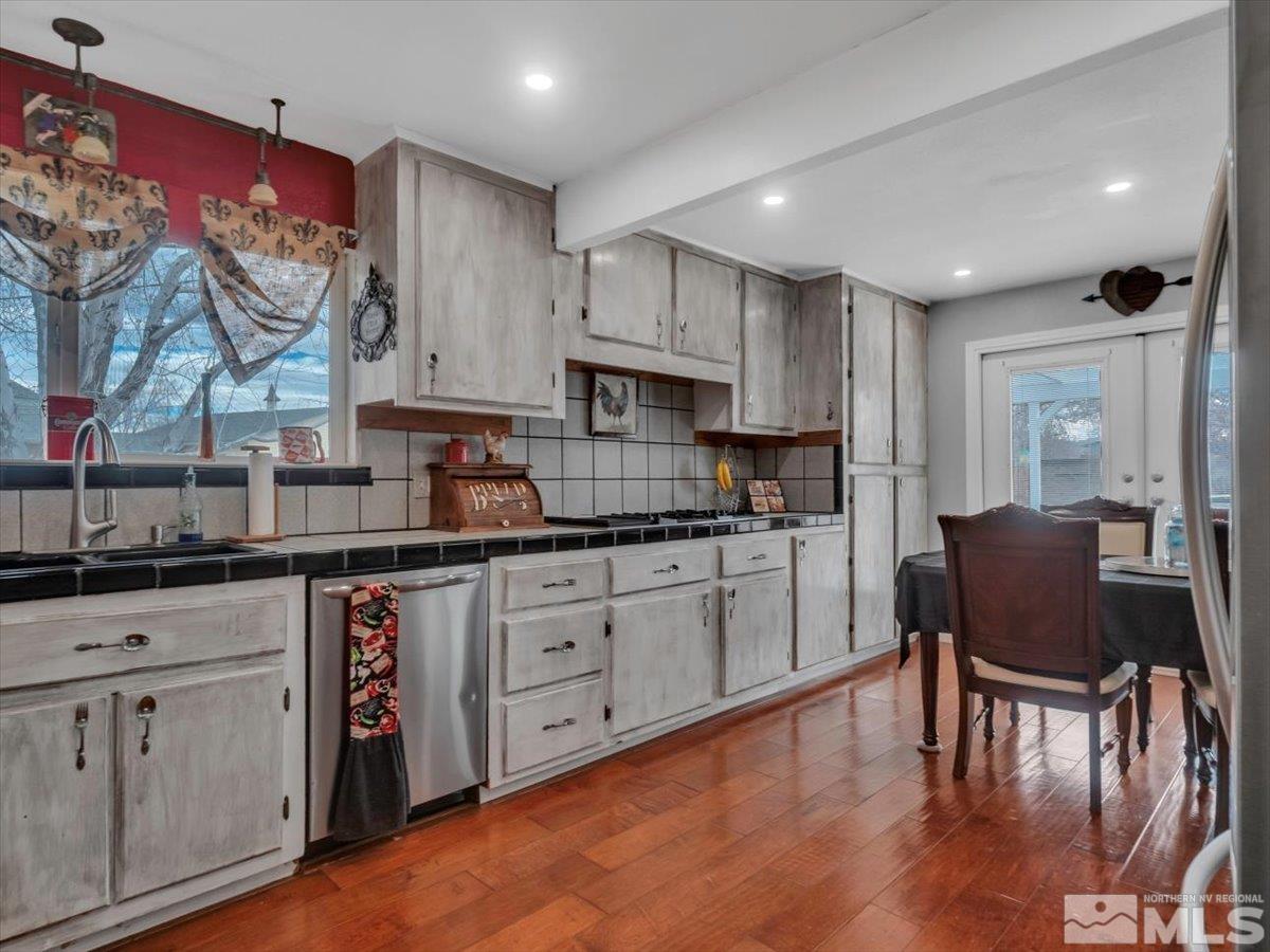 835 Russell Way Gardnerville, NV 89460 - Photo 19 of 40 a kitchen with stainless steel appliances granite countertop a stove top oven a sink dishwasher and cabinets with wooden floor