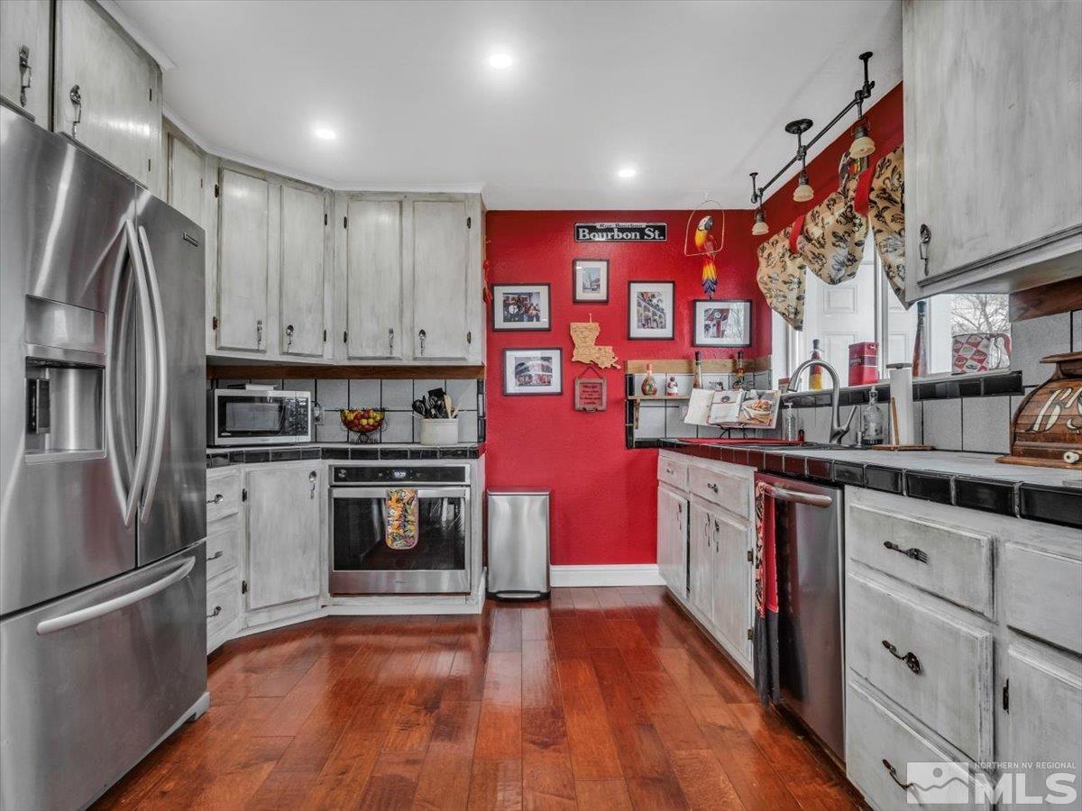 835 Russell Way Gardnerville, NV 89460 - Photo 35 of 40 a kitchen with stainless steel appliances granite countertop a refrigerator and a sink