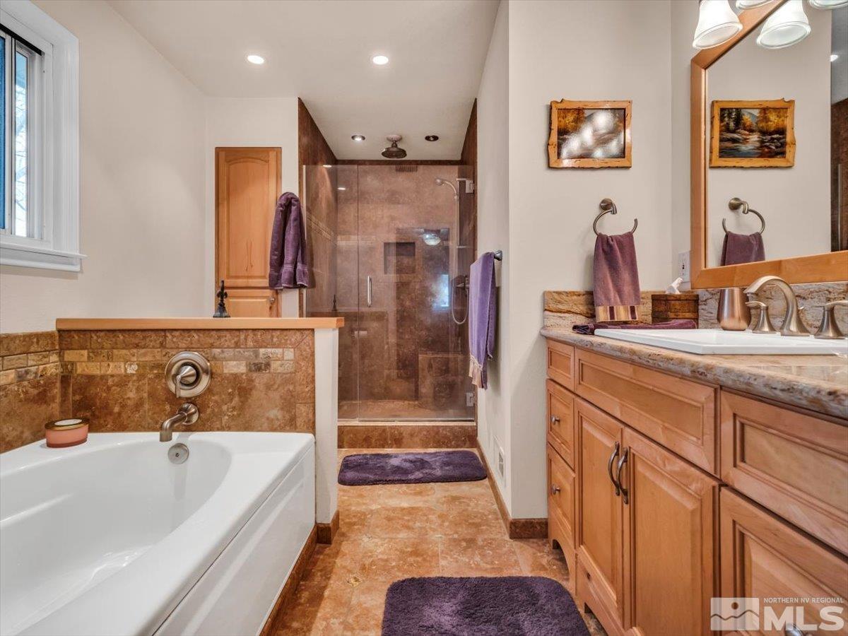 835 Russell Way Gardnerville, NV 89460 - Photo 10 of 40 a bathroom with a tub a sink and mirrors