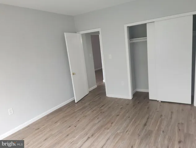 an empty room with wooden floor and closet
