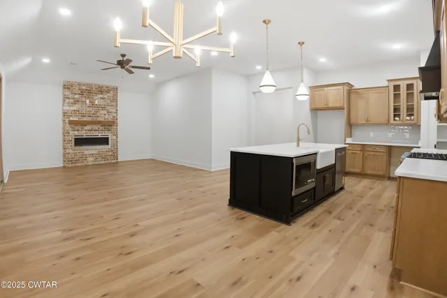 a large kitchen with kitchen island a sink stainless steel appliances and a counter top space