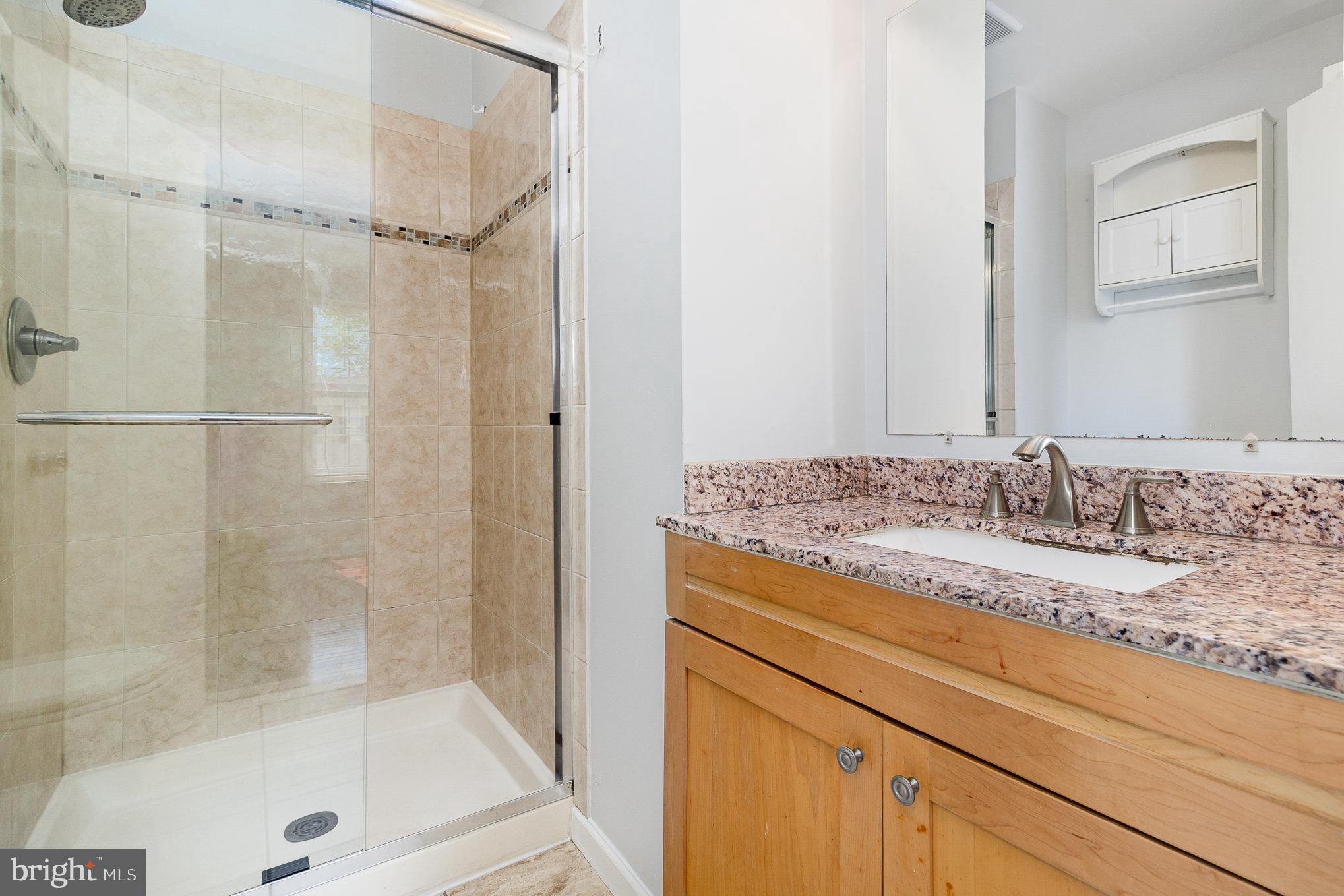 14888 Enterprise Lane Woodbridge, VA 22191 - Photo 12 of 25 a bathroom with a granite countertop sink mirror toilet and bathtub