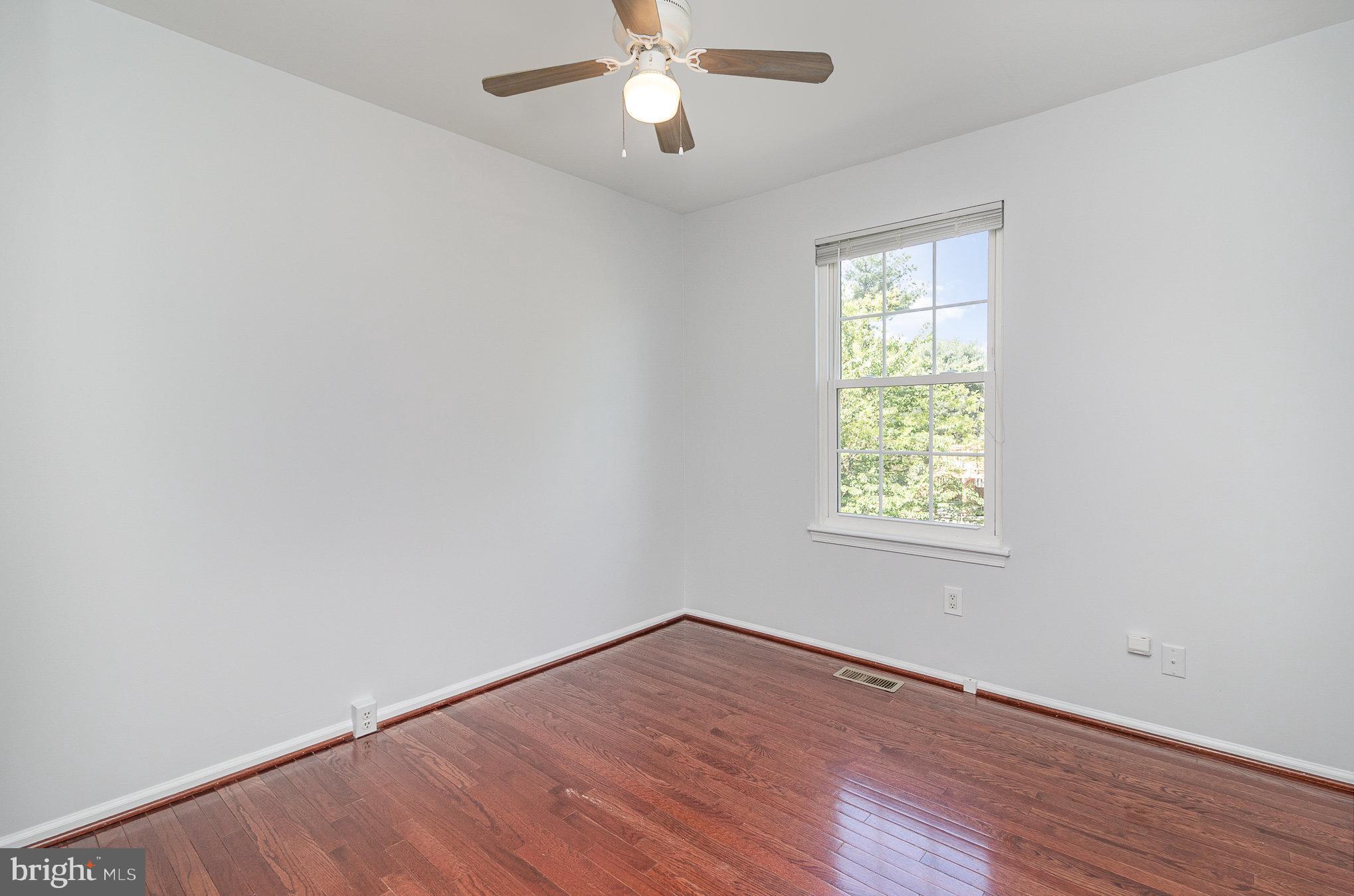 14888 Enterprise Lane Woodbridge, VA 22191 - Photo 14 of 25 an empty room with wooden floor chandelier fan and windows